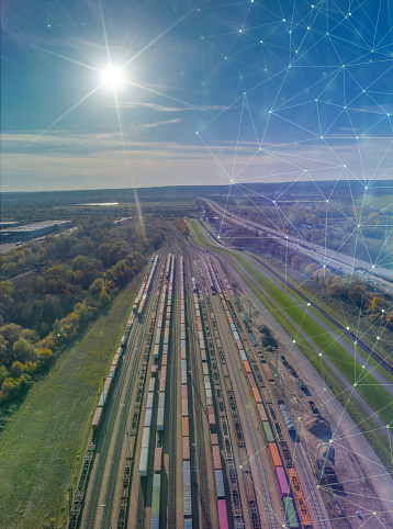 View of colorful freight trains on railway station with dynamic icons. Wagons with goods on railroad. Heavy industry. Industrial scene with cargo trains and future icons.