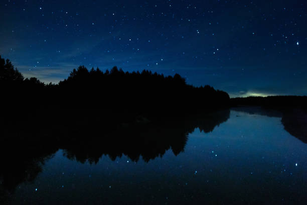 istock Night starry sky over the forest and the river 1343491401