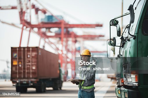 istock Worker using walkie-talkie in commercial dock 1343491755