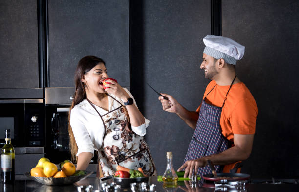 istock Couple having fun while cooking food in kitchen 1343491904