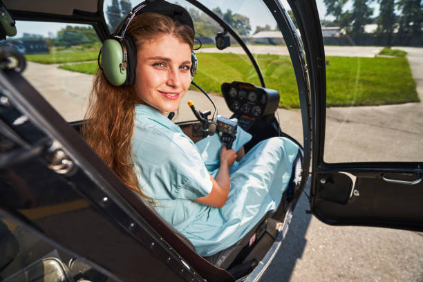 istock Joyous airwoman sitting in helicopter cabin before flight 1343492052