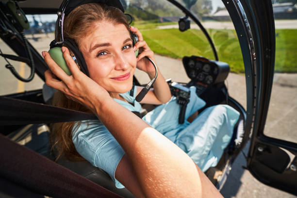 istock Joyous female pilot adjusting headset before take-off 1343492053