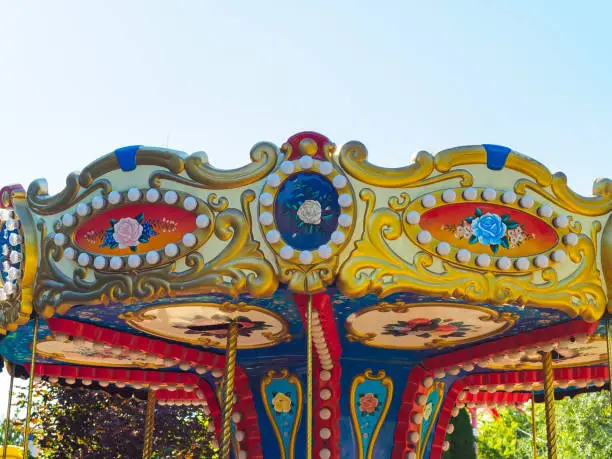 Photo of colorful roof of a revolving carousel in holiday park