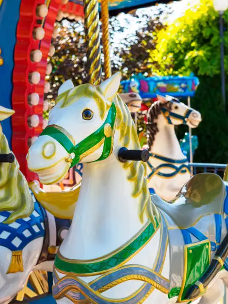 Photo of Old carousel in a holiday park. Merry-go-round with horses.