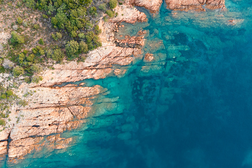View from above, stunning aerial view of a green and rocky coastline bathed by a turquoise, crystal clear water. Liscia Ruja, Costa Smeralda, Sardinia, Italy.
