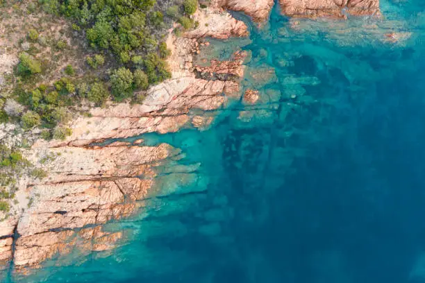 Photo of View from above, stunning aerial view of a green and rocky coastline bathed by a turquoise, crystal clear water. Liscia Ruja, Costa Smeralda, Sardinia, Italy.