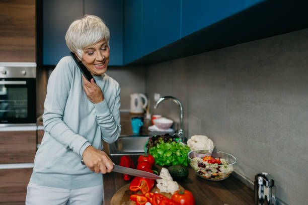 istock Woman using laptop and make a phone call in the kitchen 1343497280