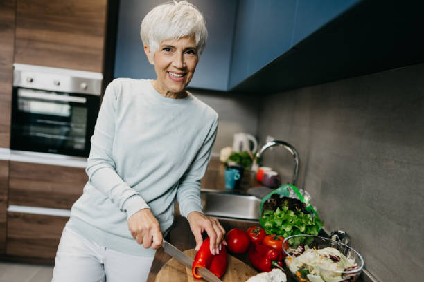 istock Woman using laptop and make a phone call in the kitchen 1343497349