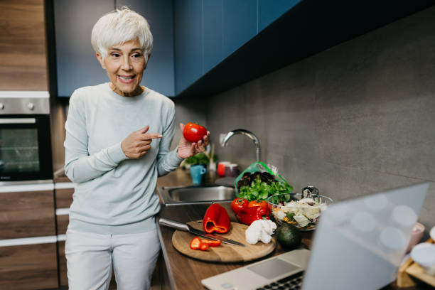 istock Woman using laptop and make a phone call in the kitchen 1343497363