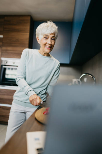 istock Woman using laptop and make a phone call in the kitchen 1343497422