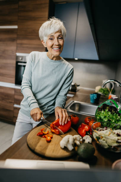 istock Woman using laptop and make a phone call in the kitchen 1343497431