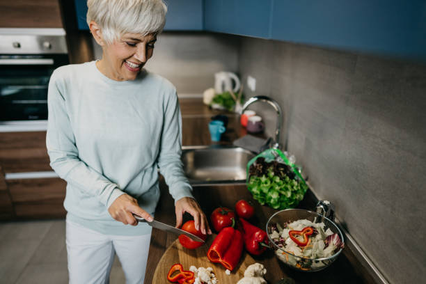 istock Woman using laptop and make a phone call in the kitchen 1343497479
