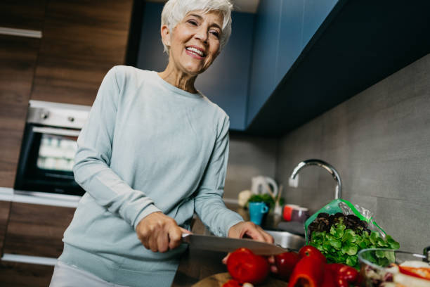 istock Woman using laptop and make a phone call in the kitchen 1343497494