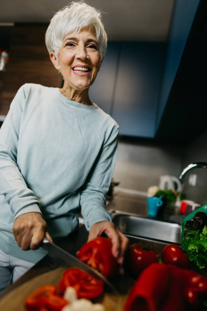 istock Woman using laptop and make a phone call in the kitchen 1343497497