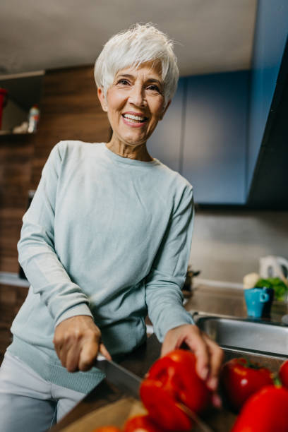 istock Woman using laptop and make a phone call in the kitchen 1343497499