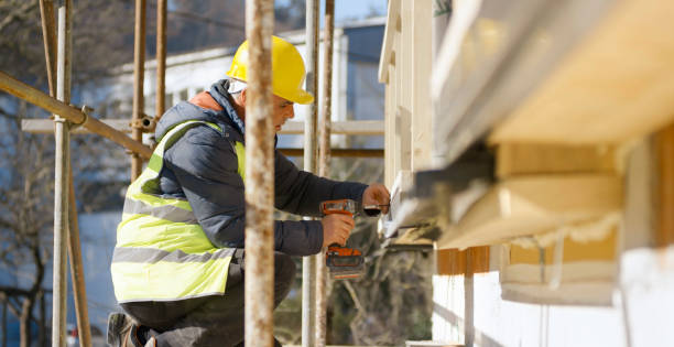 istock Male construction worker drilling hole into outer wall of house 1343498822