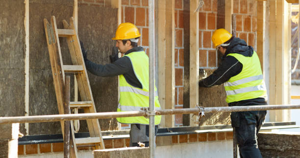 istock Construction workers placing eco insulation blocks on outer wall of house 1343498830