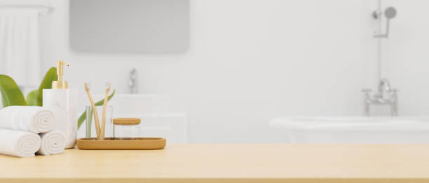 istock Wooden board or tabletop with mockup space and bath accessories over modern white bathroom interior 1343501746
