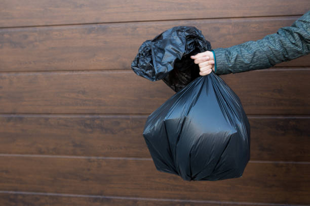 istock The guy holds a black trash bag close-up 1343502172