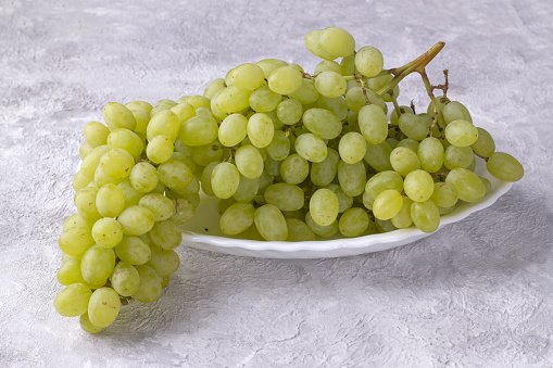 Bunch of white sweet grapes on a light background.