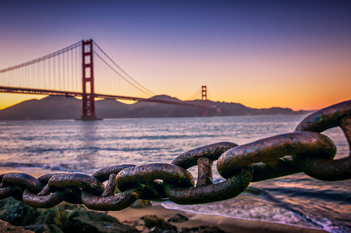 Rusty chain on the banks of the Golden Gate Bridge at sunset, San Francisco, California, USA