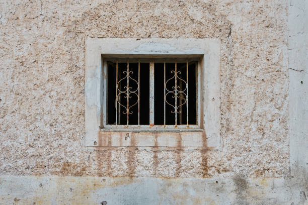 Rundown and deteriorated facade with very rustic old rusted metal fenestration