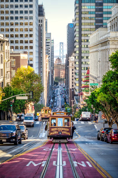 san francisco cable cars auf der california street bei sonnenaufgang, kalifornien, usa - bay bridge bridge california dawn stock-fotos und bilder