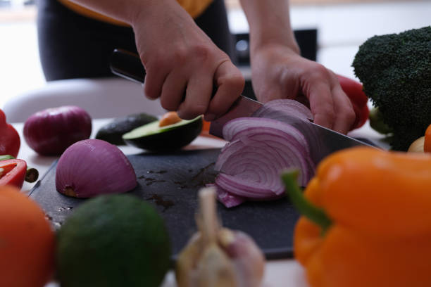 istock Woman cuts red onion into wedges closeup 1343505237