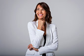 Studio shot of attractive businesswoman wearing suit while looking up and smiling