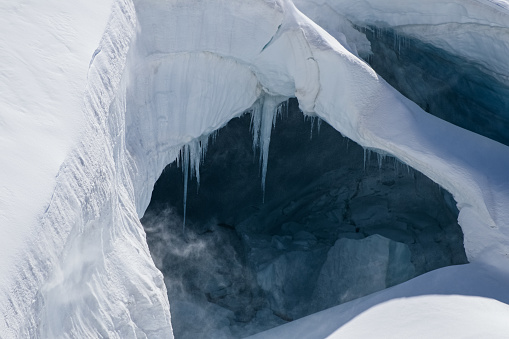 A stunning series of 14 images of the ice cover, crevasses and formations at around 12,000 feet in the Jungfrau Massif,  Switzerland, September 2021. As well as being striking images in their own right, they also serve as a pictorial record of the ice cover in Central Europe at this point in time for those monitoring Climate Change & Global Warming. The glaciers, ice sheets crevasses and caves on each of the Eiger, Monch & Jungfrau are dramatically captured in this unique set of images.\nImage 12 shows a naturally created very large ice cave with substantial stalactite icicles clinging to its roof.