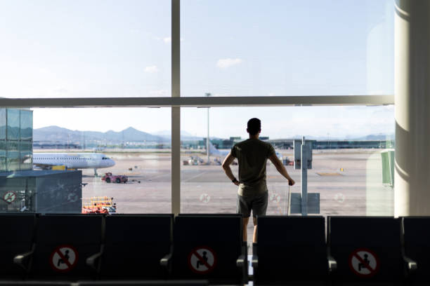 istock Man arriving in an airport with a suitcase. 1343511863