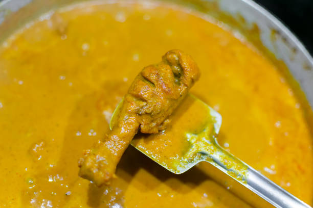 Chicken leg piece with Butter chicken gravy during the serving. Used selective focus.
