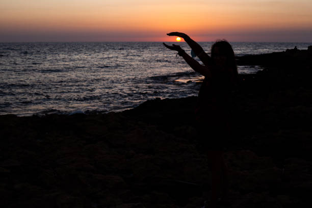 istock Woman against the light framing the sun 1343513690