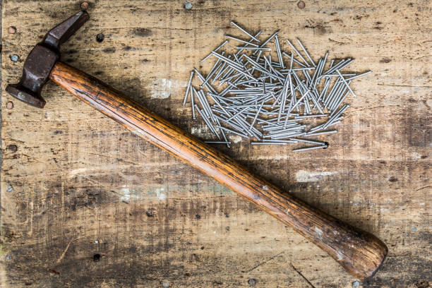 Vintage Tack Hammer And Pin Nails Flat Lay Rustic old Tack Hammer on worn bench top with nails. Landscape orientation with nails upper right. work tool nail wood construction stock pictures, royalty-free photos & images