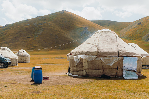 Dramatic view of traditional yurts with view of the brighting mountain range and the glacial rivers in Kyrgyzstan