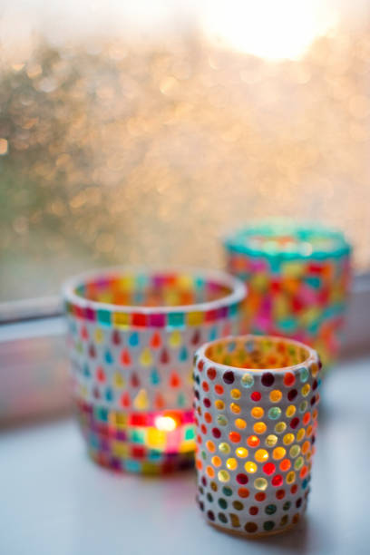 Stained turkish colorful glass candle holder with burning candles on the windowsill
