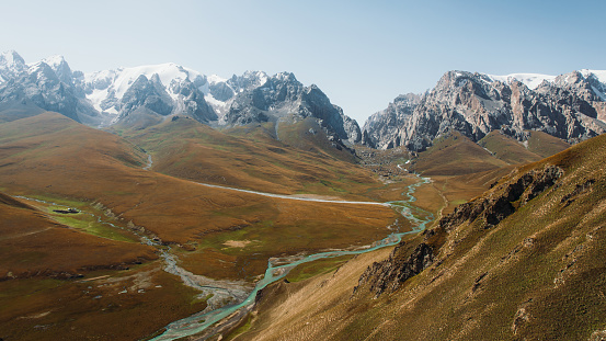 Picturesque summer mountain landscape with high peaks and the crystal blue glacier river at Tian Shan, Central Asia