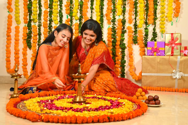 istock Mother with daughter decorating flower rangoli on floor 1343520243