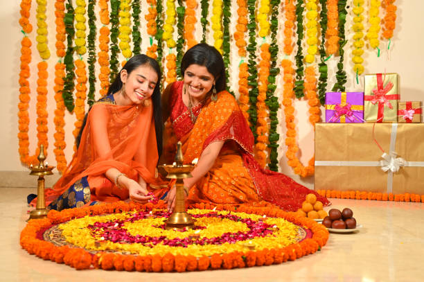 istock Mother with daughter decorating flower rangoli on floor 1343520244