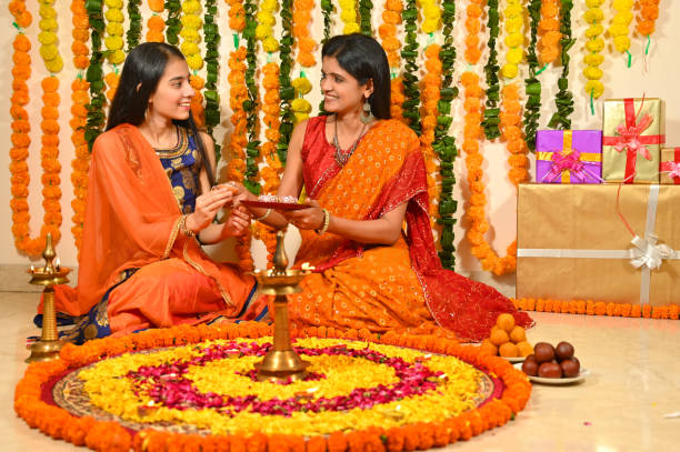 istock Mother with daughter decorating flower rangoli on floor 1343520267