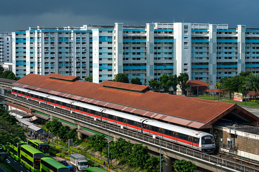 Singapore,  Sep 19, 2021 Mrt train at Yishun station, on a rainy day, against HDB blocks. Morning peak hour