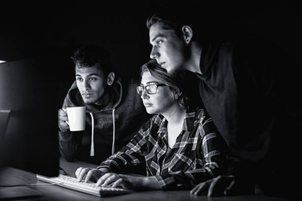 istock Group of young adults sitting at computer, focusing in deep concentration 1343521449