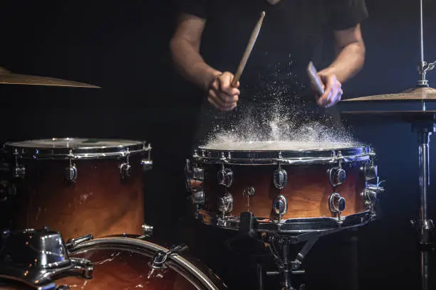Photo of The drummer plays the snare drum with splashing water.