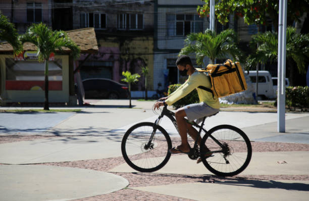 DELIVERY MAN - FOOD - BICYCLE Young man with a backpack delivering food on a bicycle in the city of Salvador, this Friday (13) (Joá Souza / Futura Press). capacete stock pictures, royalty-free photos & images
