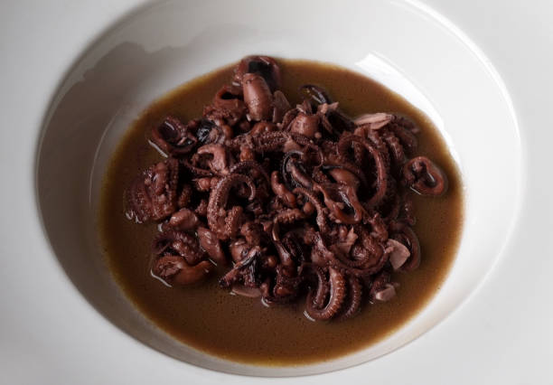 istock Small octopuses on red wine and garlic 1343525300