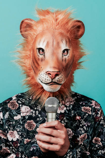 hombre con una máscara de león sostiene un micrófono - undomesticated cat audio fotografías e imágenes de stock