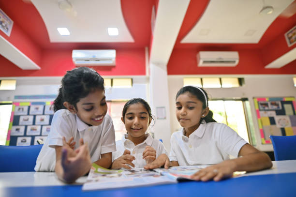istock School girls reading book together in a school library 1343526469