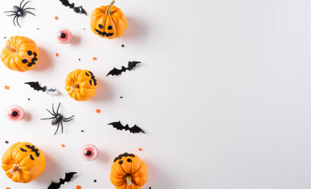 istock Halloween decorations made from pumpkin, paper bats and black spider on white background. Flat lay, top view with copy space for text. 1343527694