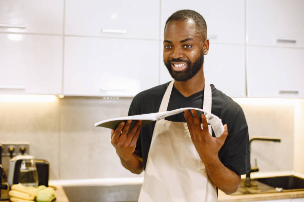 istock African-american man in a kitchen and reading a cooking book 1343529192