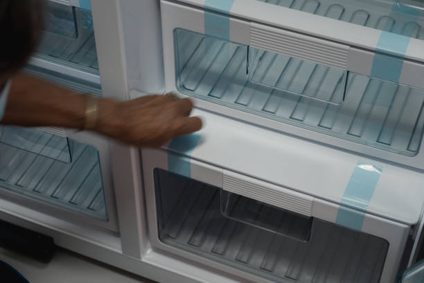 istock Hand old man peel off the sticker from new refrigerator. Close up 1343532928